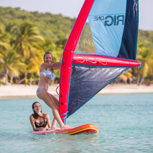 Two women enjoying windsurfing on a tropical beach.